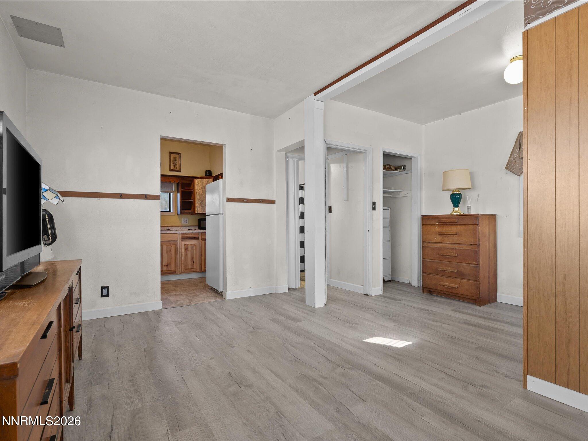 75 South Center Street, Unit A B Fernley, NV 89408 - Photo 19 of 41 a view of a kitchen with a refrigerator a stove top oven hallway wooden floor and a living room