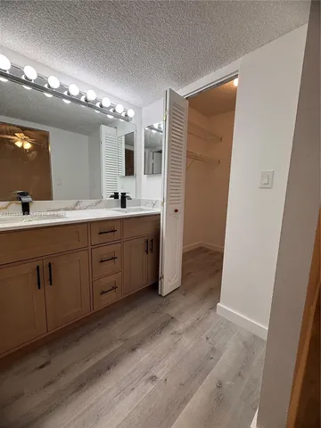 a spacious bathroom with a double vanity sink a large mirror and a shower