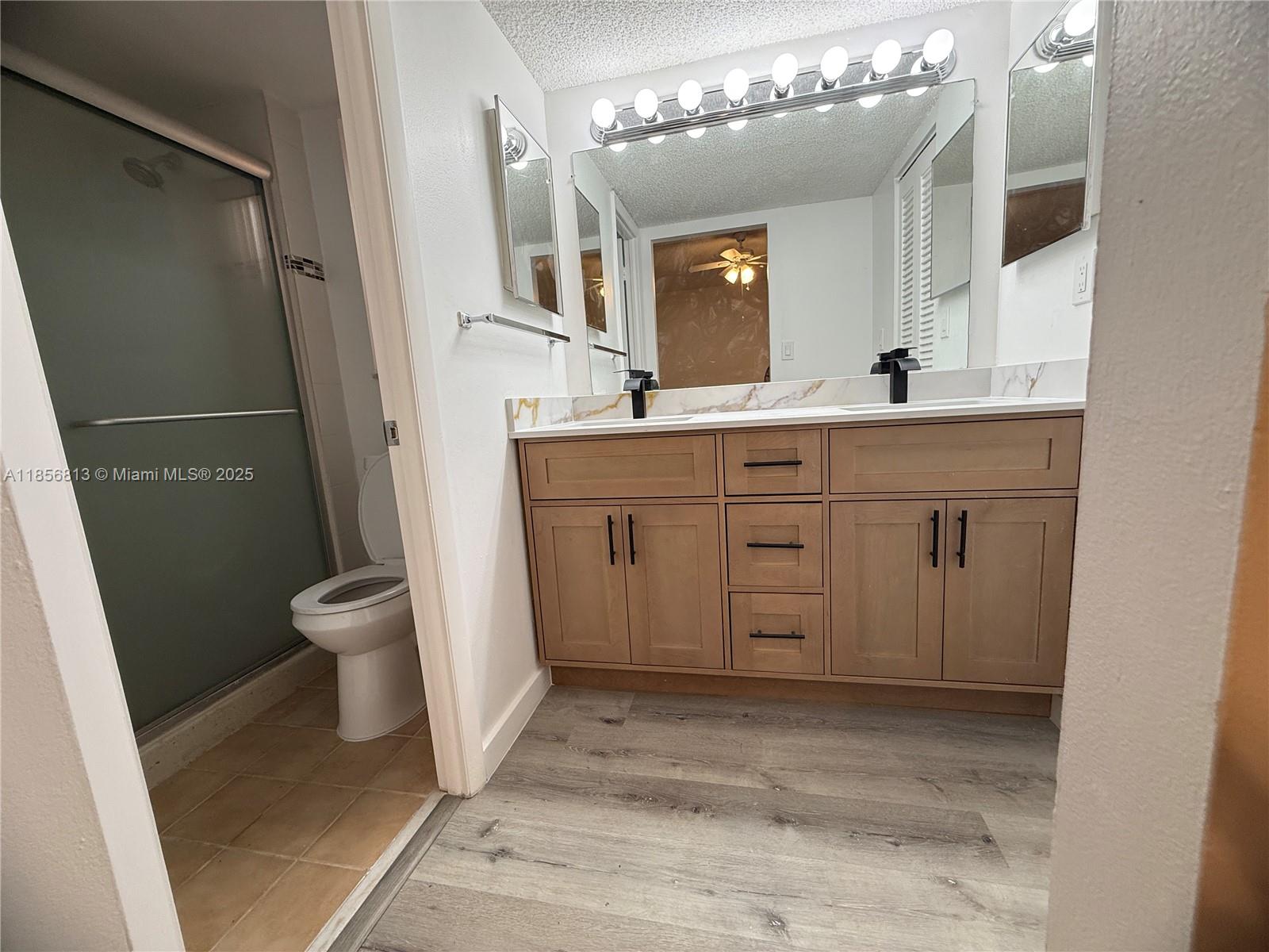 20441 Northeast 30th Avenue, Unit 1129 Aventura, FL 33180 - Photo 10 of 16 a spacious bathroom with a sink a toilet a mirror and shower