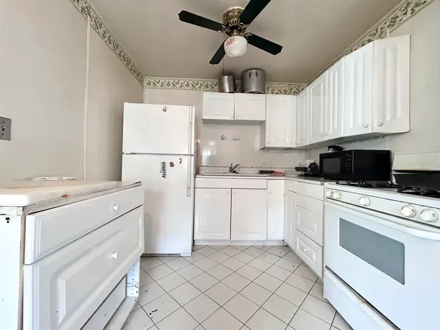 a kitchen with white cabinets and white appliances