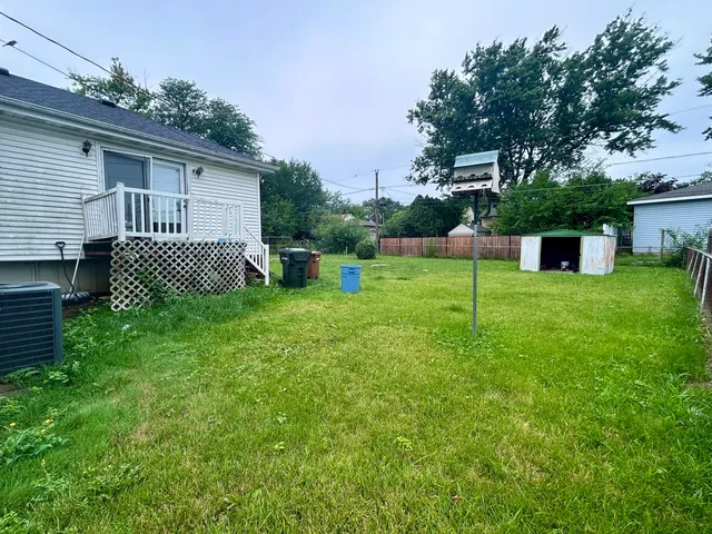 a view of a backyard with table and chairs and wooden fence