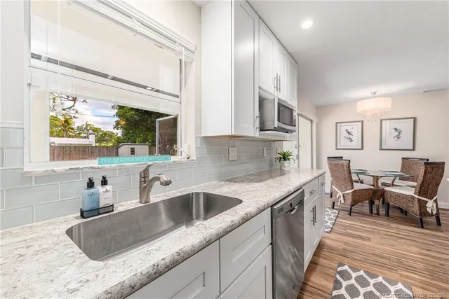 a kitchen with stainless steel appliances granite countertop a sink and a wooden cabinets