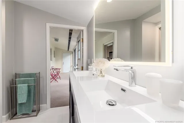 a bathroom with a tub sink and mirror