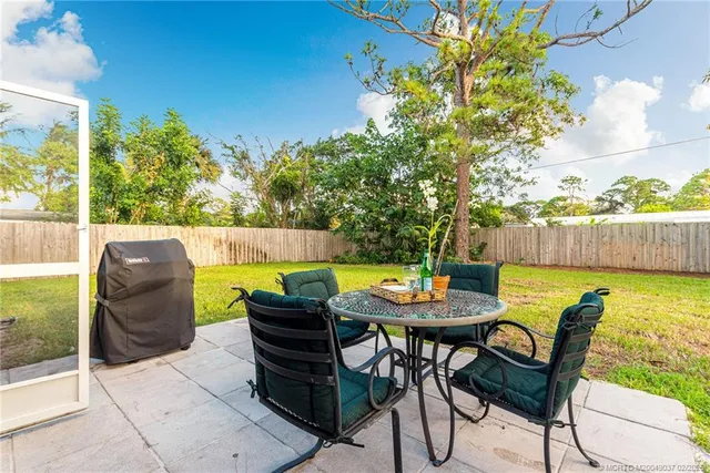 a view of a patio with table and chairs and potted plants