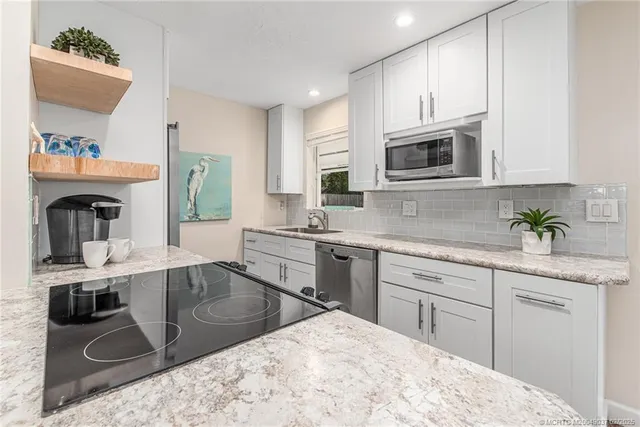 a kitchen with stainless steel appliances kitchen island granite countertop a sink and cabinets