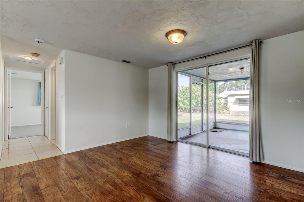 5753 Bantam Avenue New Port Richey, FL 34652 - Photo 11 of 47 wooden floor in an empty room with a window