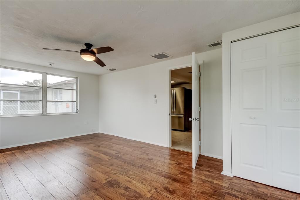 5753 Bantam Avenue New Port Richey, FL 34652 - Photo 23 of 47 a view of empty room with wooden floor and fan