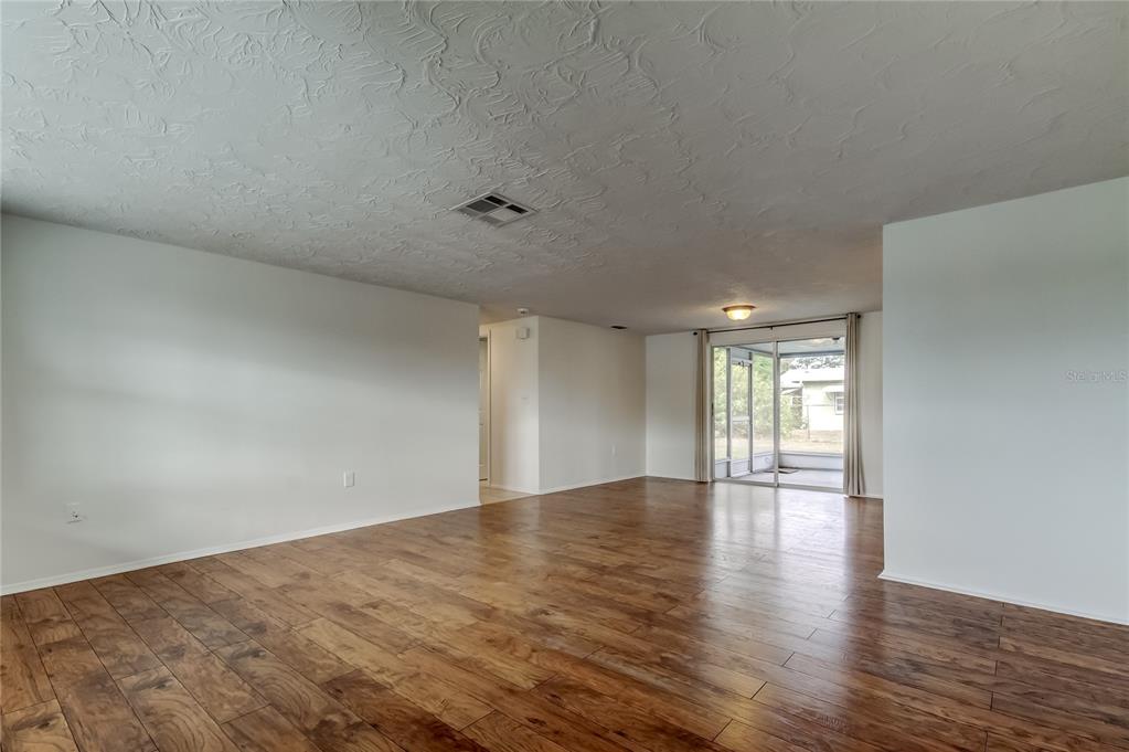 5753 Bantam Avenue New Port Richey, FL 34652 - Photo 4 of 47 a view of an empty room with wooden floor and a window
