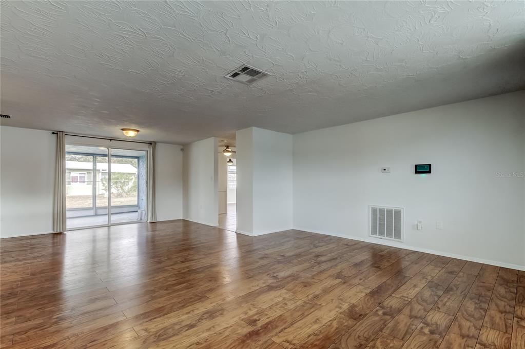 5753 Bantam Avenue New Port Richey, FL 34652 - Photo 7 of 47 a view of an empty room with wooden floor and a window