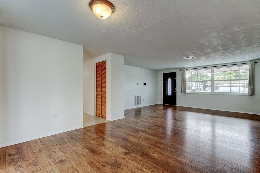 5753 Bantam Avenue New Port Richey, FL 34652 - Photo 9 of 47 an empty room with wooden floor and windows