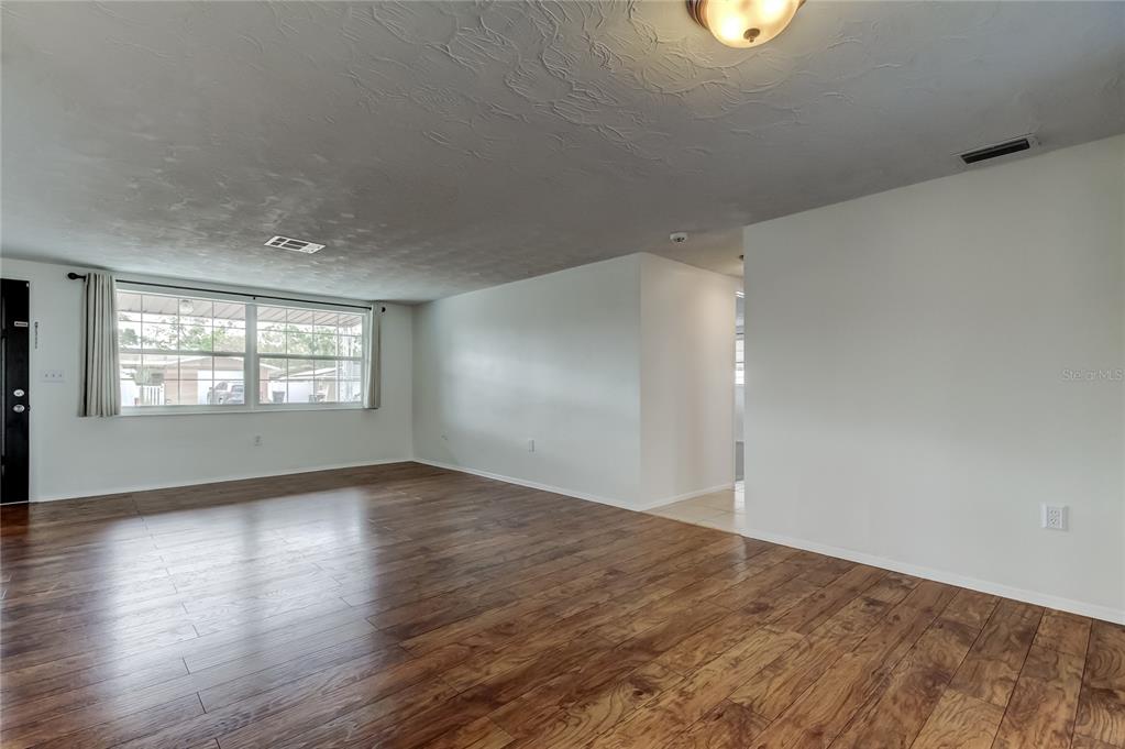 5753 Bantam Avenue New Port Richey, FL 34652 - Photo 10 of 47 an empty room with wooden floor and windows
