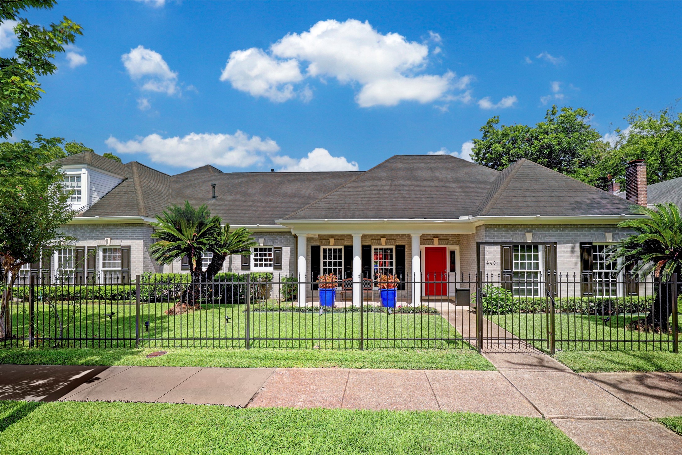 a view of a house with a big yard and potted plants