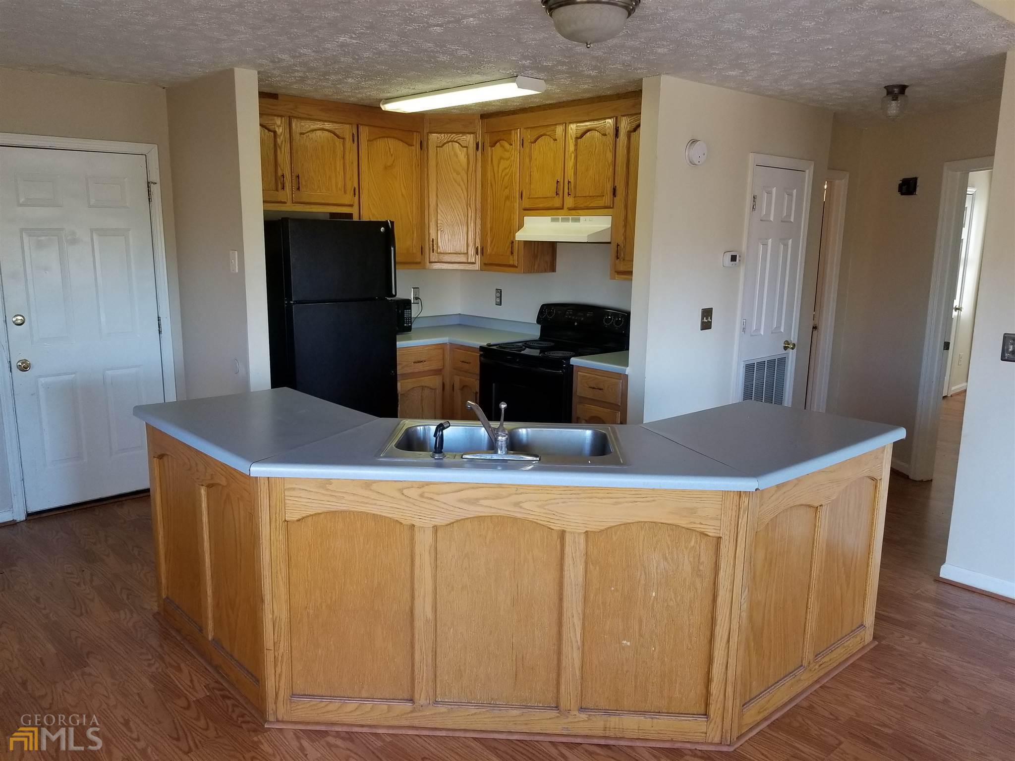 163 Tommy Barnett Road Nicholson, GA 30565 - Photo 5 of 14 a kitchen with kitchen island wooden cabinets and refrigerator