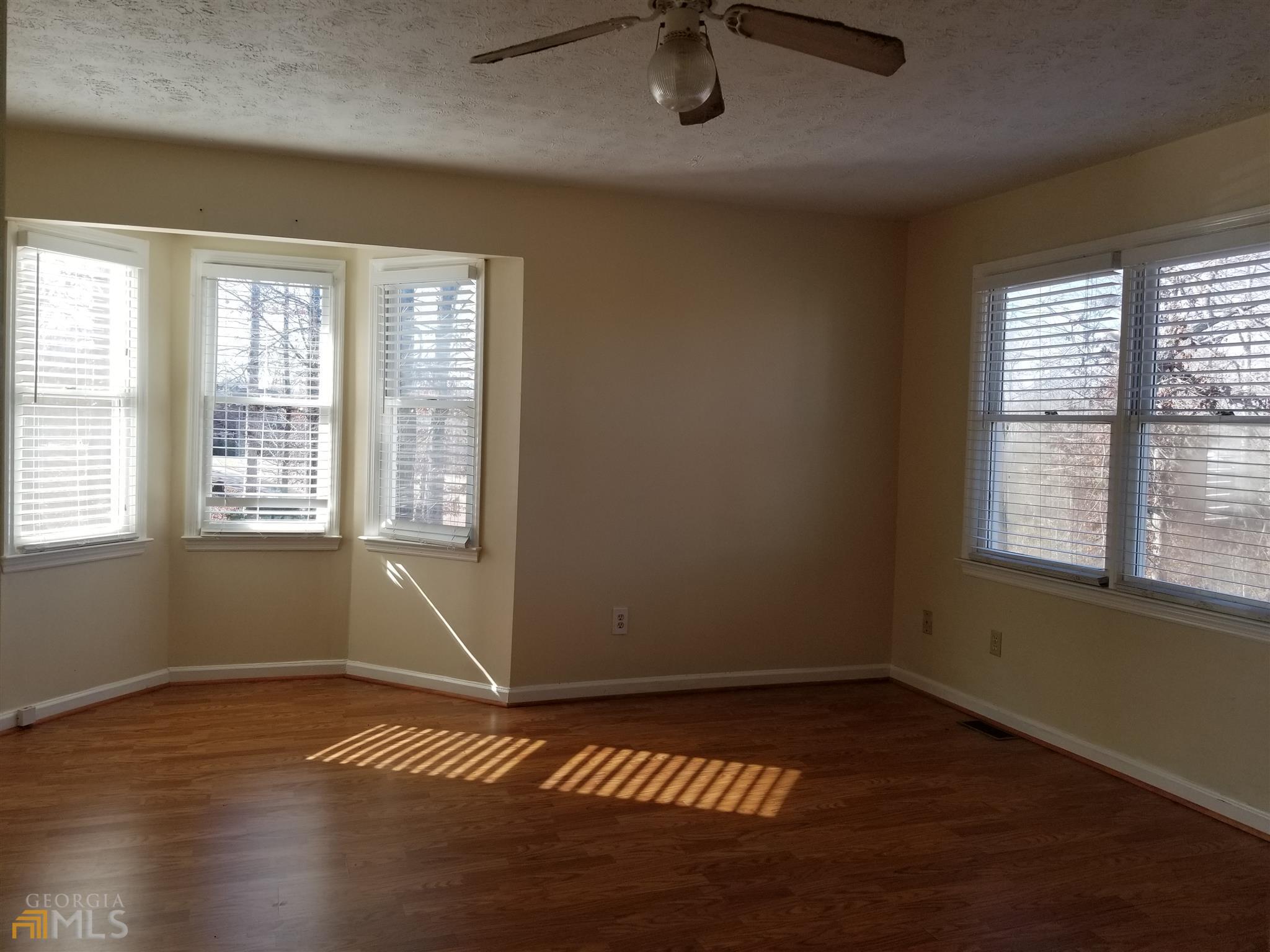 163 Tommy Barnett Road Nicholson, GA 30565 - Photo 6 of 14 an empty room with wooden floor and windows