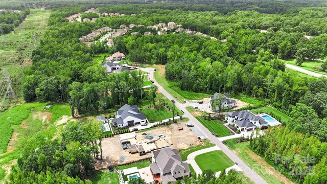 an aerial view of residential house with outdoor space and trees all around