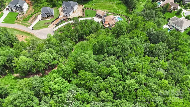 an aerial view of residential house with outdoor space and trees all around