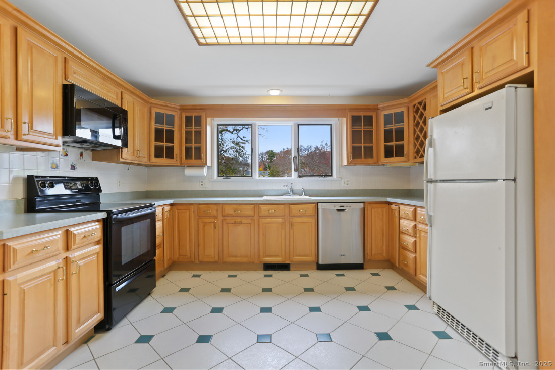 97 Field Point Drive, Unit 97 Fairfield, CT 06824 - Photo 11 of 40 a kitchen with granite countertop a refrigerator and a stove top oven