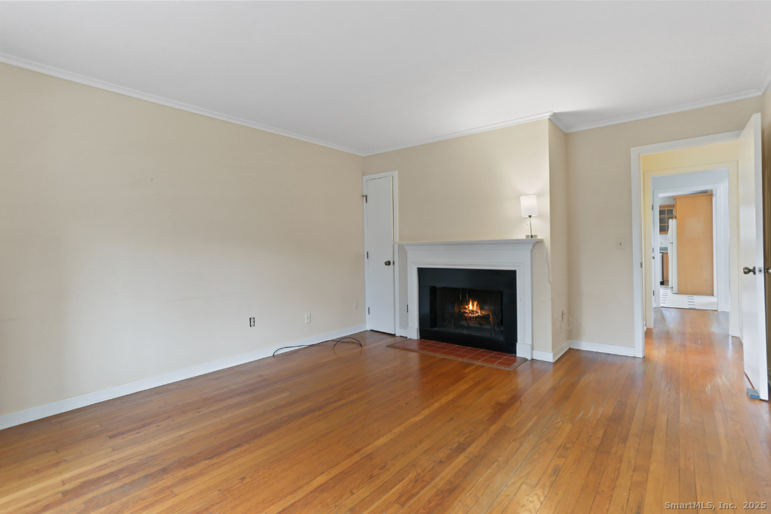 97 Field Point Drive, Unit 97 Fairfield, CT 06824 - Photo 16 of 40 a view of an empty room with wooden floor fireplace and a window