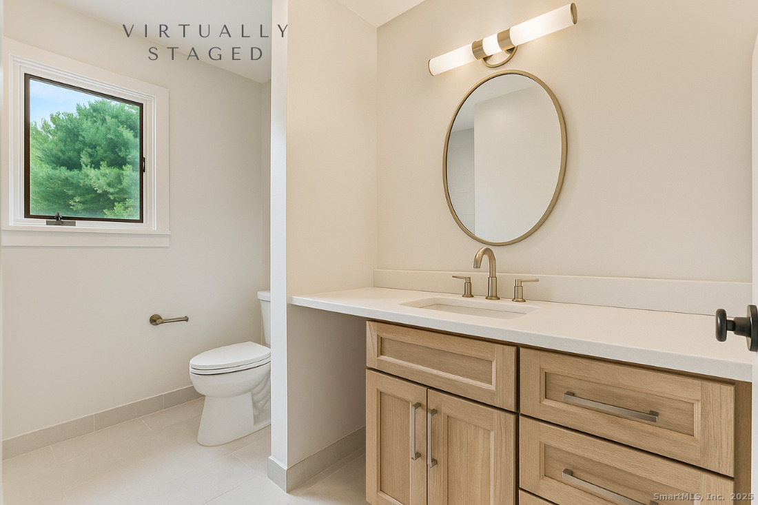 97 Field Point Drive, Unit 97 Fairfield, CT 06824 - Photo 24 of 40 a bathroom with a toilet sink and mirror