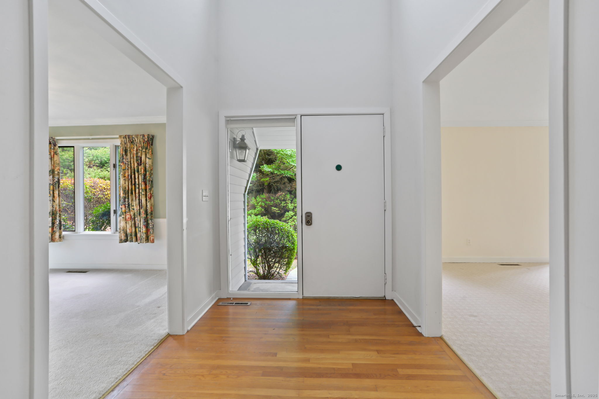 97 Field Point Drive, Unit 97 Fairfield, CT 06824 - Photo 5 of 40 a view of an empty room with wooden floor and a window