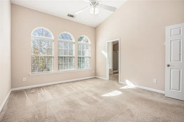 an empty room with windows and fan