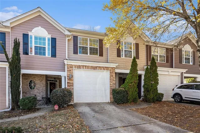 a view of a white house with a large windows and a yard