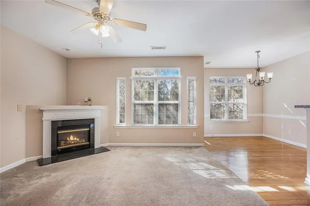 a view of an empty room with window and fire place
