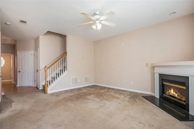 a view of an empty room with staircase and fireplace