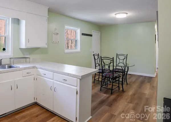 a view of a kitchen area with furniture and wooden floor