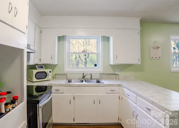 a kitchen with a sink a stove and cabinets