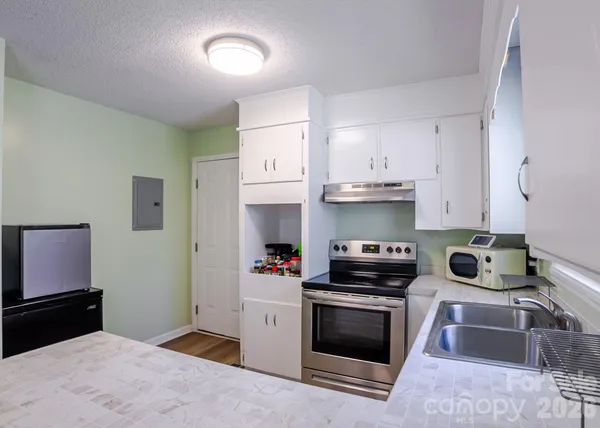 a kitchen with granite countertop a sink stove and cabinets