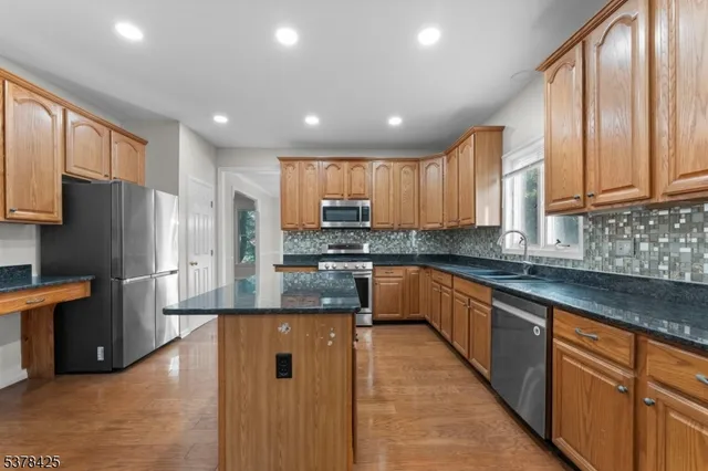 a large kitchen with granite countertop a large counter top stainless steel appliances and cabinets