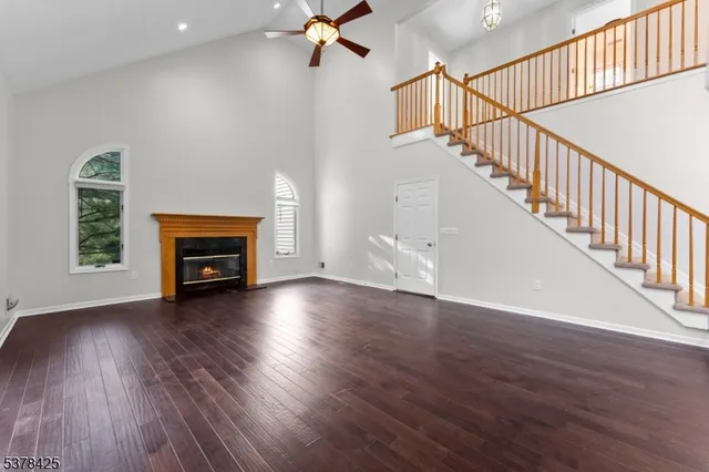a view of empty room with fireplace and wooden floor