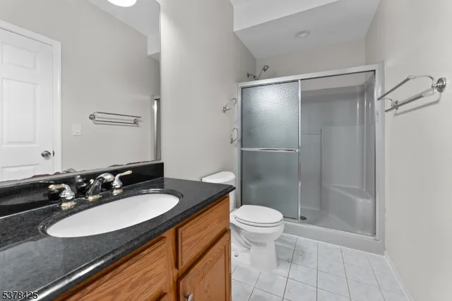 a bathroom with a sink a toilet a mirror and shower