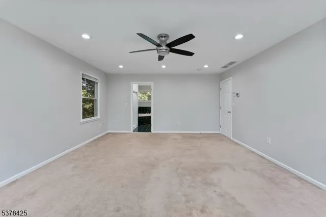 a view of an empty room with a ceiling fan