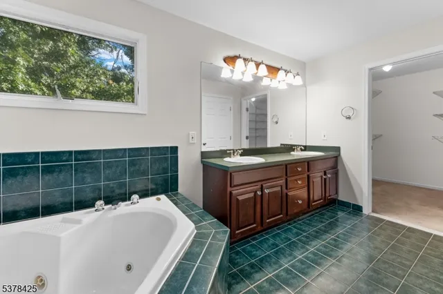 a bathroom with a tub sink and mirror