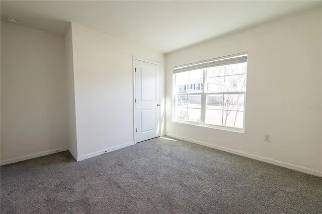an empty room with a window and a ceiling fan