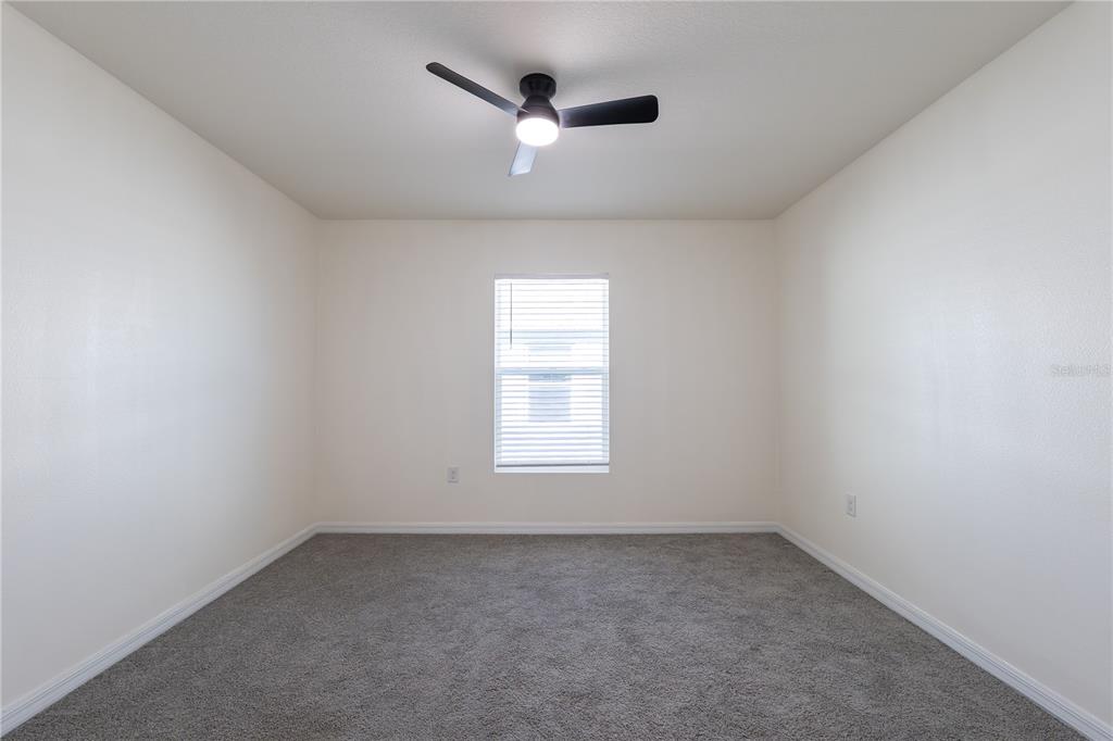 11272 Southeast 67th Circle Belleview, FL 34420 - Photo 13 of 24 an empty room with a window and a ceiling fan