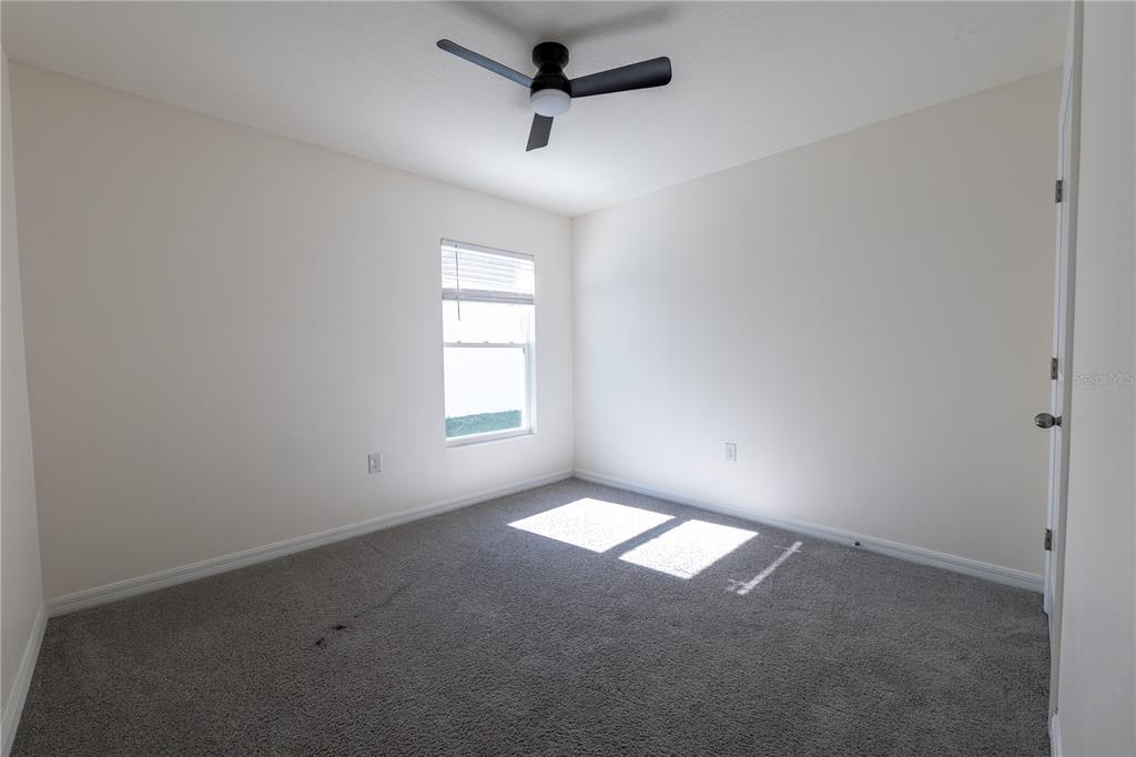 11272 Southeast 67th Circle Belleview, FL 34420 - Photo 20 of 24 an empty room with windows and fan