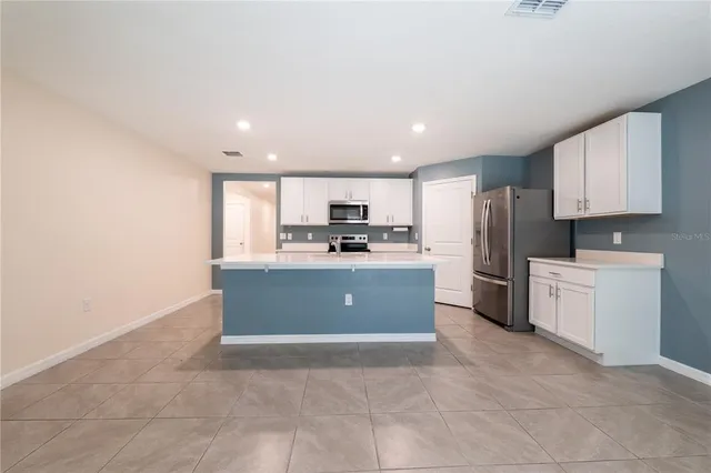 a kitchen with stainless steel appliances a refrigerator sink and microwave