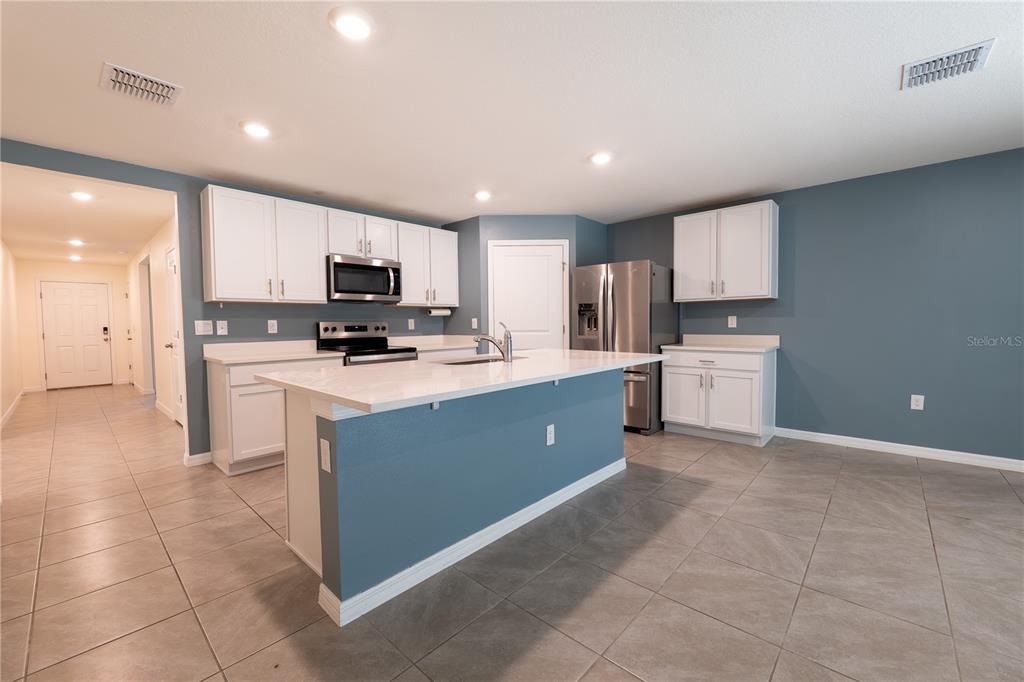 11272 Southeast 67th Circle Belleview, FL 34420 - Photo 6 of 24 a kitchen with cabinets a microwave a sink and a counter top space