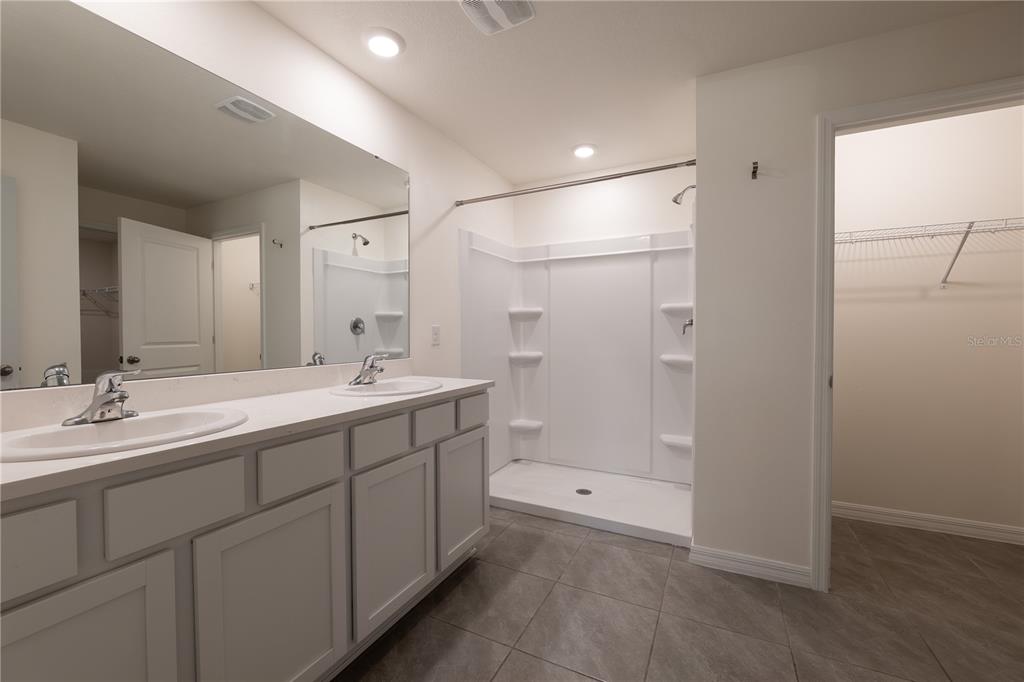 11272 Southeast 67th Circle Belleview, FL 34420 - Photo 10 of 24 a bathroom with a double vanity sink mirror and shower