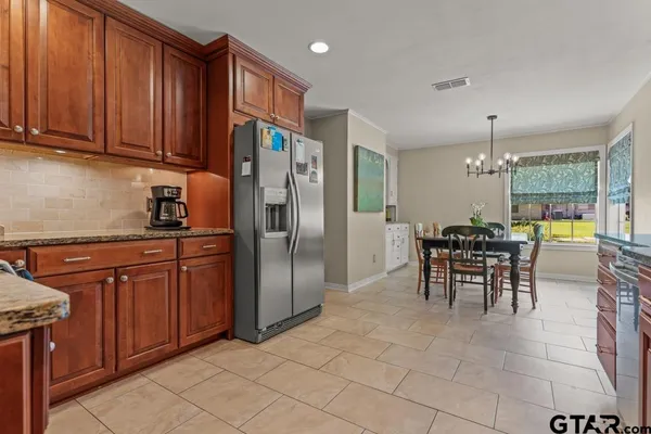 a kitchen with stainless steel appliances granite countertop a refrigerator and a stove top oven