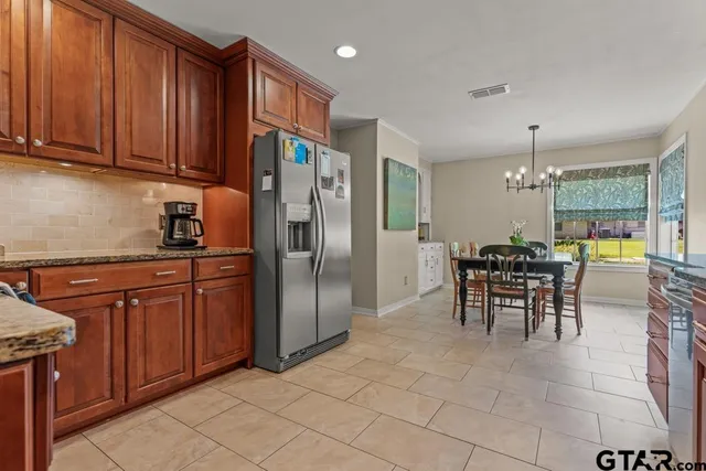 a kitchen with stainless steel appliances granite countertop a refrigerator and a stove top oven