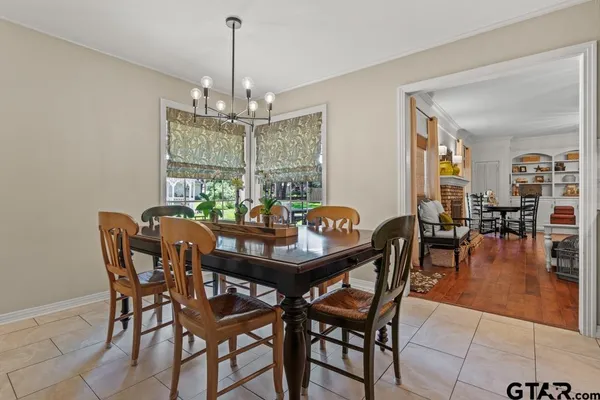 a dining room with furniture a chandelier and window