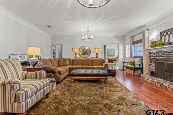 a living room with furniture a fireplace and a chandelier