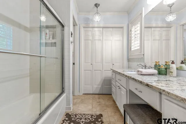 a bathroom with a granite countertop sink a mirror and a shower