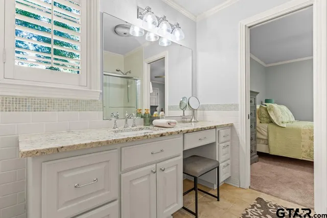 a en suite bathroom with a granite countertop sink and a mirror