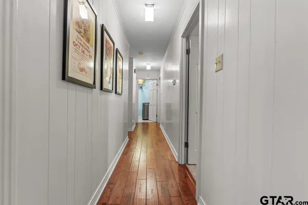 a view of a hallway with wooden floor