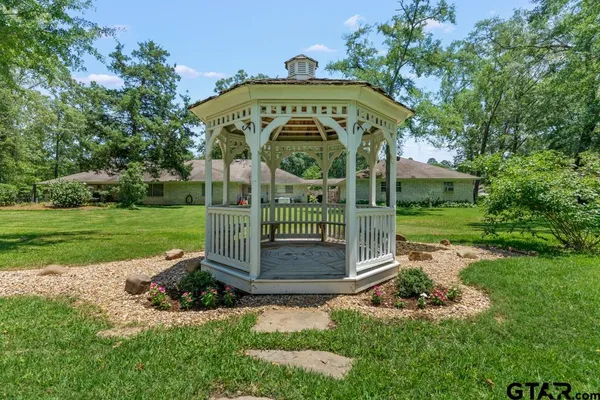 a view of a house with a yard and potted plants